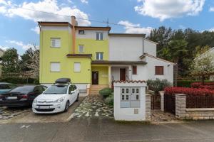 a white car parked in front of a house at Apartment Luna in Poreč