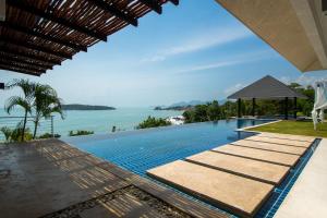 a swimming pool with the ocean in the background at Bluemango Pool Villa & Resort Koh Samui in Koh Samui 