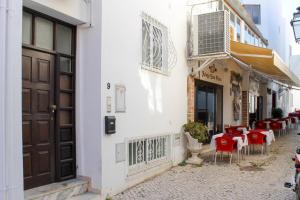 a restaurant with red tables and chairs on a street at Sofeelings, Estudio Sol, Baixa de Albufeira in Albufeira