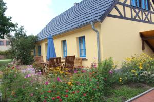 a house with chairs and flowers in the yard at Ferienhof Kchischowka in Vetschau