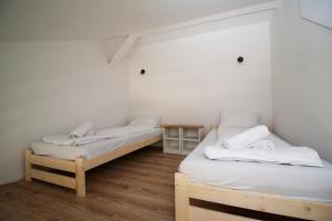 2 letti in una camera con pareti bianche e pavimenti in legno di Forrest Jantar a Jantar