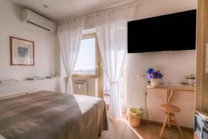 a bedroom with a bed and a large window at La Casa Sul Mare in Civitavecchia