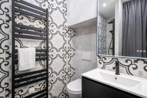 W łazience znajduje się umywalka, toaleta i lustro. w obiekcie La librairie parisienne-Convention, Porte de Versailles w Paryżu