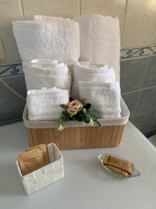 un cesto di asciugamani e un fiore su un tavolo di Casa Silvia a Pescara