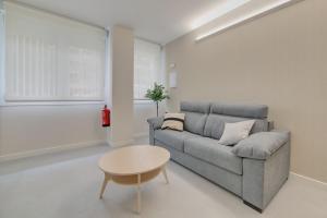 sala de estar con sofá y mesa en Apartamentos Pamplona Confort by Clabao, en Pamplona