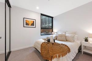 - une chambre blanche avec un grand lit et une fenêtre dans l'établissement Love Peace and Style, à Melbourne
