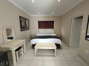 a bedroom with a bed and a table and a mirror at Amber Selfcatering in Clarens