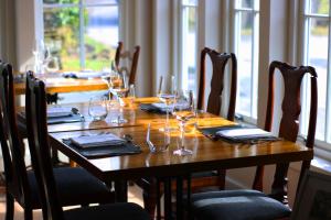 a wooden table with wine glasses and napkins on it at Tigh an Truish Inn in Oban