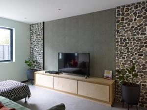 a living room with a flat screen tv on a wall at Grand Designs Chess Valley Project - Rickmansworth in Rickmansworth