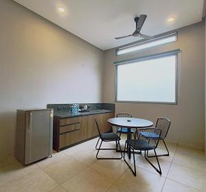 a kitchen with a table and chairs and a window at VAMA Retreats in Bangalore