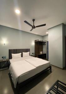 1 dormitorio con 1 cama y ventilador de techo en VAMA Retreats en Bangalore