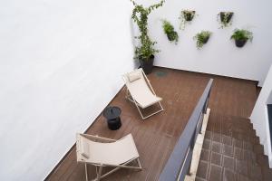 twee stoelen en een tafel in een kamer met planten bij Brito Capelo 183 in Matosinhos