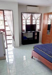 a bedroom with a bed and a flat screen tv at TG2 - Tientong Guesthouse 2 in Hua Hin