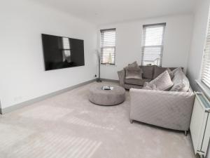 sala de estar con sofá y TV en The Annexe, en Berwick-Upon-Tweed