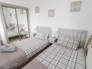 a bedroom with two beds and a mirror at The Annexe in Berwick-Upon-Tweed