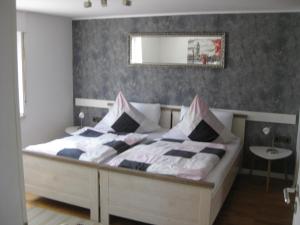 ein Schlafzimmer mit einem großen Bett und einem Spiegel an der Wand in der Unterkunft Bella Colonia Vieren in Hürth