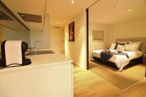 a bedroom with a bed and a kitchen with a mirror at Heavenly Chic Apartment & only 30m to Bridge Road 01578 in Melbourne