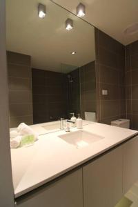 a bathroom with a sink and a large mirror at Heavenly Chic Apartment & only 30m to Bridge Road 01578 in Melbourne