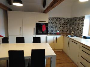 a kitchen with white cabinets and a table with chairs at Apartmány Vojnův Městec in Vojnŭv Městec