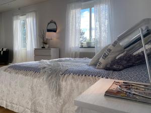 a white bedroom with a bed and a window at Snibben Höga Kusten in Ramvik