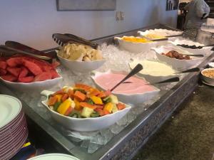 a buffet with bowls of different types of fruits and vegetables at Holiday Inn Accra Airport, an IHG Hotel in Accra