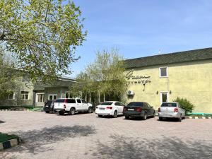 un grupo de coches estacionados frente a un edificio en Green Hotel en Atyraū