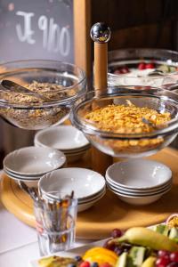 a table topped with bowls and plates of food at HOTEL BREMER TOR, Bestes Hotelfrühstück, Self-Check-In 24 h in Vechta