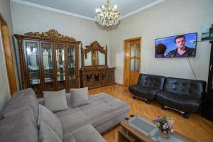 a living room with a couch and a chandelier at Barnaba Apartment in Tbilisi City