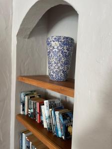 a book shelf with a vase and books at Casa Balena - Gansbaai seafront accommodation, back-up power in Gansbaai