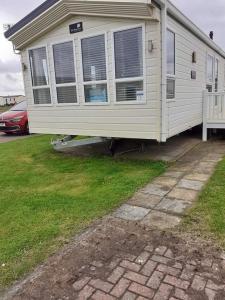 a mobile home with a bench in a yard at 19 orchid Meadows in Newbiggin-by-the-Sea