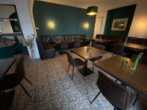 a restaurant with tables and chairs and a green wall at Hotel Vier Löwen in Traben-Trarbach