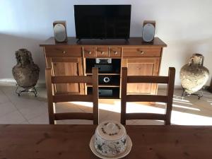 a living room with a tv and two chairs at "Triacanthos" 2 bedroom house in Moutsoúna
