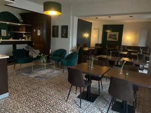 特拉本特拉巴赫的住宿－菲爾羅聞酒店，餐厅设有木桌和绿色椅子