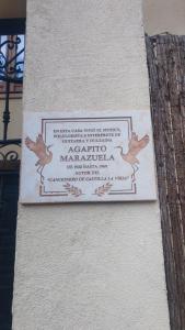 un cartello sul lato di un edificio con degli uccelli di Casa Agapito Marazuela a Segovia