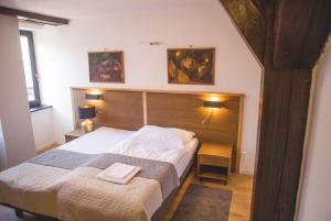 a bedroom with a bed and two pictures on the wall at Penzión ÁTRIUM in Prešov