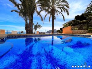 a large blue swimming pool with palm trees at VH CostaBlanca - EVA in Benissa