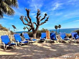 a group of blue chairs and a tree at VH CostaBlanca - EVA in Benissa