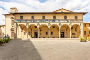 a large building with arches and a clock tower at La Sapienza in Pistoia