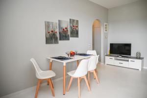 uma sala de jantar com uma mesa e cadeiras brancas em Santamare Studio em Ayios Sostis