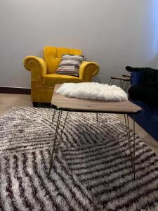 a living room with a yellow couch and a rug at Romantic, Stunning & Authentic Ensuited Master Bedroom in Dar es Salaam