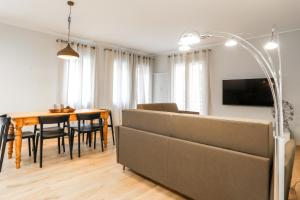 a living room with a couch and a dining room table at Treviso City Town 4 in Treviso