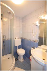 uma casa de banho azul com um WC e um lavatório em Guest House Lav em Primošten