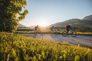 a group of three people riding bikes down a road at Blick auf's Schloss in Itter