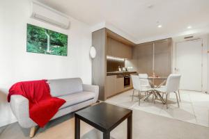 a living room with a couch and a table at Nice 1 bedroom close to Albert Park Lake 02053 in Melbourne