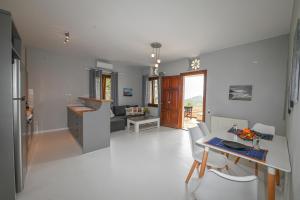 a kitchen and living room with a table and chairs at Santamare Studio in Agios Sostis