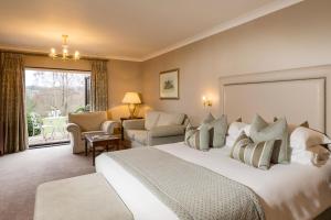 um quarto de hotel com uma cama grande e uma varanda em Ashdown Park Hotel em Forest Row