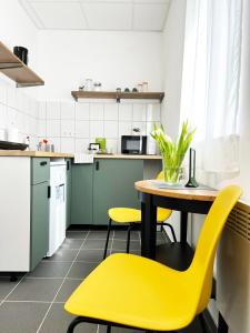 a kitchen with a table and yellow chairs at Árkádia Vendégház in Lábatlan
