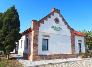 a building with a sign on the side of it at Árkádia Vendégház in Lábatlan