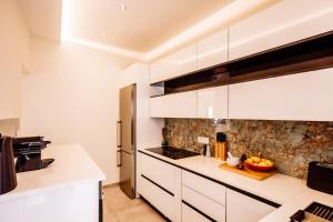 a kitchen with white cabinets and a refrigerator at Deviazi 4 in Zakynthos Town