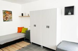 a bedroom with a bed and a white cabinet at Árkádia Vendégház in Lábatlan